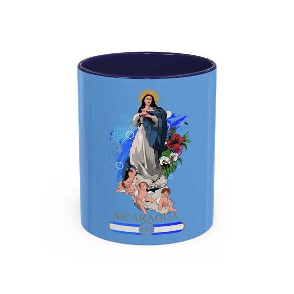 Una taza de café de cerámica azul con un colorido diseño floral y una ilustración de la Virgen María sosteniendo a un niño, con el nombre 'NICARAGUA' impreso en la parte inferior.