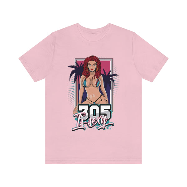 Una llamativa camiseta con temática de Miami que lleva la frase "305 is sexy". El diseño incluye la ilustración de una mujer en bikini azul claro sobre un fondo rosa fucsia, flanqueada por palmeras a ambos lados.