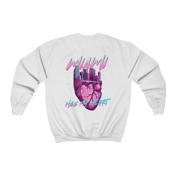 El diseño presenta el horizonte de Miami en forma de corazón y las palabras "Miami tiene mi corazón". La combinación de colores incluye rosa intenso, azul celeste y blanco, que recuerda a South Beach.